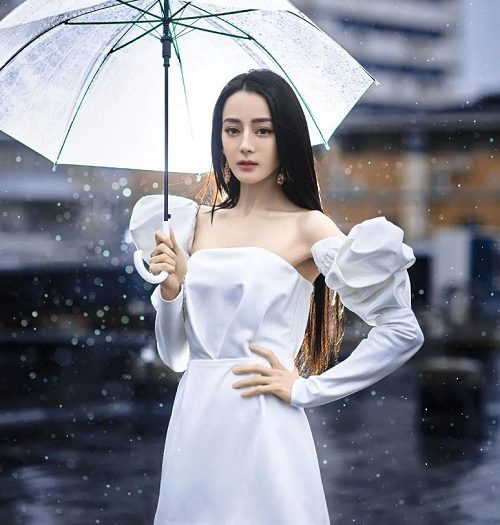 迪丽热巴穿小白裙雨中撑伞，瘦到衣服快挂不住了